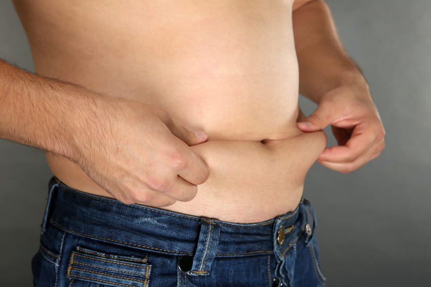 Un homme qui touche son gros ventre